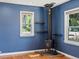 Bright living room featuring blue walls, hardwood floors, and a charming wood-burning stove at 1580 Youngfield St, Lakewood, CO 80215