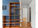 Living room with a built-in shelving unit and hardwood floors flows into other areas of the home at 1580 Youngfield St, Lakewood, CO 80215
