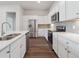 A kitchen featuring stainless steel appliances, sleek white cabinets, and a stylish gray backsplash at 485 Interlocken Blvd # 103, Broomfield, CO 80021