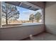 View from porch through large opening of tree filled landscape, open sky and patches of snow at 485 Interlocken Blvd # 103, Broomfield, CO 80021