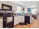 Kitchen with white cabinets, black appliances, and view of dining area at 4982 W Kentucky Ave, Denver, CO 80219