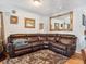 Living room with large brown leather sectional sofa at 4982 W Kentucky Ave, Denver, CO 80219