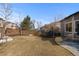 Large backyard features a trampoline, patio, and wooden fence, perfect for outdoor enjoyment at 9925 Keenan St, Highlands Ranch, CO 80130