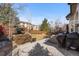 Well-maintained backyard with patio area, privacy fence, mature trees, and outdoor seating at 9925 Keenan St, Highlands Ranch, CO 80130