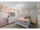 Bright bedroom with floral accent wall, white furniture, and natural light from the window at 9925 Keenan St, Highlands Ranch, CO 80130