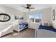 Bright bedroom featuring two twin beds, natural light, and soft neutral walls with modern ceiling fan and carpeted floors at 9925 Keenan St, Highlands Ranch, CO 80130