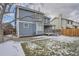 View of the home's exterior, deck, and backyard with a dusting of snow at 4334 Liverpool Ct, Denver, CO 80249