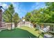 Backyard deck with astroturf surrounded by a green leafy yard, seating, and a white railing at 19075 E Grand Cir, Aurora, CO 80015
