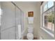 Bright bathroom featuring a glass enclosed shower, toilet, and a window for natural light at 19075 E Grand Cir, Aurora, CO 80015