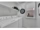 Functional laundry room with modern washer and dryer units, storage shelves, and bright natural light at 19075 E Grand Cir, Aurora, CO 80015