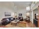 Bright living room features soaring ceilings, large windows, hardwood floors, and comfortable leather furniture at 19075 E Grand Cir, Aurora, CO 80015