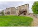 Spacious backyard view showing the home's exterior, lush lawn, and wooden deck stairs at 5546 Echo Hollow St, Castle Rock, CO 80104