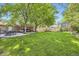 Expansive backyard with lush lawn, patio, deck, and mature trees at 7331 S Webster St, Littleton, CO 80128