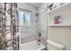 Bathroom featuring a shower-tub combination, tiled walls, and a decorative shower curtain at 7331 S Webster St, Littleton, CO 80128
