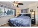 Bedroom featuring a queen bed, ceiling fan and a window with natural light at 7331 S Webster St, Littleton, CO 80128