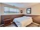 Bedroom with neutral colors featuring a bed, window, and dresser at 7331 S Webster St, Littleton, CO 80128