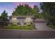 Charming two-story home with a well-maintained lawn, mature trees, and attached garage at 7331 S Webster St, Littleton, CO 80128