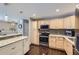 Well-lit kitchen featuring wood cabinets, granite countertops, stainless steel appliances, and hardwood floors at 7331 S Webster St, Littleton, CO 80128