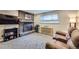 Cozy living room featuring a brick fireplace and comfortable seating at 7331 S Webster St, Littleton, CO 80128