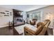 Inviting living room featuring a brick fireplace, bay window, hardwood floors, and comfortable seating at 7331 S Webster St, Littleton, CO 80128