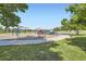 A playground is visible with a play structure, a swing set and seating area with blue skies and mature trees at 7331 S Webster St, Littleton, CO 80128
