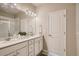 Bright bathroom featuring a double vanity, sleek countertops, modern fixtures and a glass door walk-in shower at 6817 Huddersfield Ln, Castle Pines, CO 80108