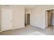 A bright bedroom featuring plush carpet, multiple doorways, and white trim at 6817 Huddersfield Ln, Castle Pines, CO 80108