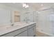 Bright bathroom featuring a double sink vanity, a glass shower, and a walk in closet at 4757 Windmill Dr, Brighton, CO 80601