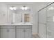Bright bathroom featuring a double sink vanity, a glass shower, and a walk in closet at 4757 Windmill Dr, Brighton, CO 80601