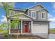 Two-story home featuring gray siding, stone accents, a red front door, and a two-car garage at 4757 Windmill Dr, Brighton, CO 80601