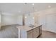 Kitchen island with granite countertops and stainless steel sink, opening into adjacent living area at 4757 Windmill Dr, Brighton, CO 80601