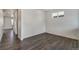 Bright living room with wood-look flooring, white walls, and a window providing ample natural light at 4757 Windmill Dr, Brighton, CO 80601