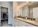 Bathroom with double sinks, a large mirror, ample counter space, and a walk-in shower, designed for convenience at 6882 Huddersfield Ln, Castle Pines, CO 80108