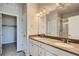 Elegant bathroom featuring dual sinks, a large mirror, and stylish lighting fixtures at 6882 Huddersfield Ln, Castle Pines, CO 80108