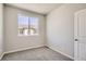 This bedroom has gray carpet, walls, and trim with a large bright window at 6882 Huddersfield Ln, Castle Pines, CO 80108