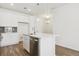 Open concept kitchen features white cabinetry, stainless steel dishwasher, and a quartz countertop island at 6882 Huddersfield Ln, Castle Pines, CO 80108
