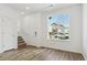 Well-lit living room with wood floors, staircase, and a large window providing ample natural light at 6882 Huddersfield Ln, Castle Pines, CO 80108