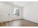 Bright living room with hardwood floors, white walls, and a large window overlooking the neighborhood at 6882 Huddersfield Ln, Castle Pines, CO 80108