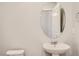 A pristine powder room with an oval mirror above the pedestal sink at 6882 Huddersfield Ln, Castle Pines, CO 80108