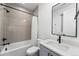 This bathroom features modern fixtures, sleek gray tile, and a shower-tub combination at 2255 S Monroe St, Denver, CO 80210