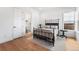 Stylish bedroom featuring hardwood floors, a wrought iron bed, and ample natural light at 2255 S Monroe St, Denver, CO 80210