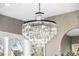 Close-up of dining room's dazzling crystal chandelier with windows bringing in light at 2255 S Monroe St, Denver, CO 80210
