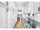 Hallway features white cabinets and drawers with black hardware and stone countertop with a glimpse into the dining room at 2255 S Monroe St, Denver, CO 80210