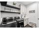 Functional laundry room with modern washer/dryer, storage shelves, and ample counter space at 2255 S Monroe St, Denver, CO 80210