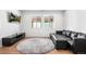 Living room featuring wood floors, a black leather couch and a large window allowing for ample natural light at 2255 S Monroe St, Denver, CO 80210