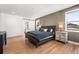 Modern bedroom with hardwood floors, neutral wall, and ensuite bath through sliding barn door at 2255 S Monroe St, Denver, CO 80210
