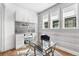 Bright home office with gray and white striped wallpaper, built-in cabinets and drawers, and a glass desk at 2255 S Monroe St, Denver, CO 80210