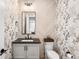 Chic powder room featuring patterned wallpaper, modern vanity, and updated fixtures at 2255 S Monroe St, Denver, CO 80210