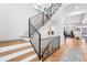Open staircase with hardwood steps and black iron railings complements the home's style at 2255 S Monroe St, Denver, CO 80210