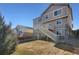 A well-manicured lawn with a wooden fence, a deck with staircase, neutral siding, and stone accents at 24317 E Powers Ave, Aurora, CO 80016